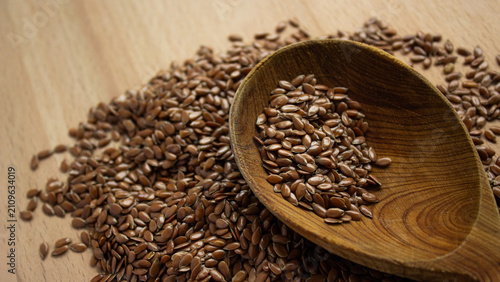 Obraz na płótnie Flax seeds in wooden spoon on wooden background closeup