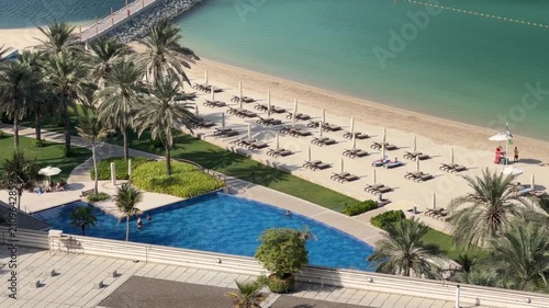 Aerial View of Luxury Tropical Beach Resort with Turquoise Ocean, Swimming Pool, Sun loungers and Palm Trees on a Sunny Day