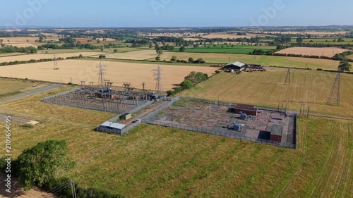 Close up aerial view of small electrical substation transformers and high voltage pylons