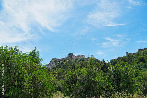 Obraz na płótnie Scenic view of Xàtiva Castle standing atop a limestone hill above Mediterranean vegetation in Xàtiva, Valencia, Spain