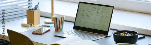 Konstfotografi Wide shot of laptop displaying calendar on desk beside smartphone and notebook, supporting schedule planning and task management