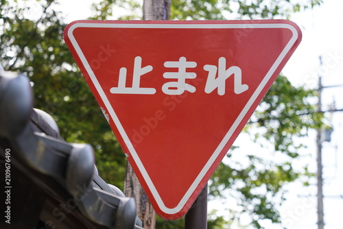 Red Japanese stop sign on a rural street corner