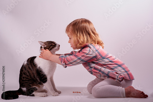 Bild auf Leinwand a girl who loves to play with animals and feed them, especially cats