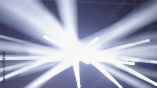 Powerful stage spotlights creating dramatic light beams at live event