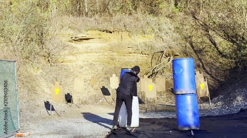 Elegant Man Training Dynamic Shooting IDPA in an Outdoor Shooting Range with a Modern Handgun in a Sunny Day in Switzerland. (Slow Motion)