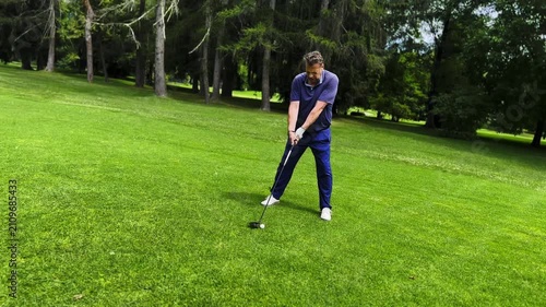 Male Golfer Hitting the Golf Ball on Fairway on Golf Course in a Hot Sunny Summer Day in Switzerland.