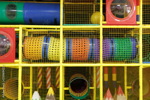 Colorful indoor playground with soft play tunnels, climbing structures, and safety nets. Perfect for children's entertainment, family recreation, play centers, and indoor activity concepts.