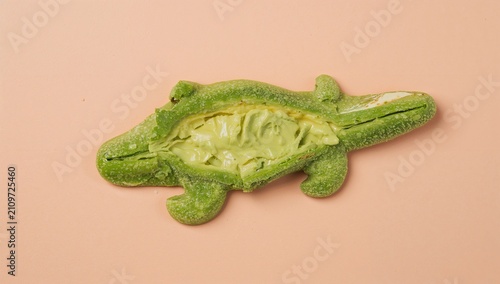 Konstfotografi Green Alligator-Shaped Pastry Filled with Cream on Light Pink Surface