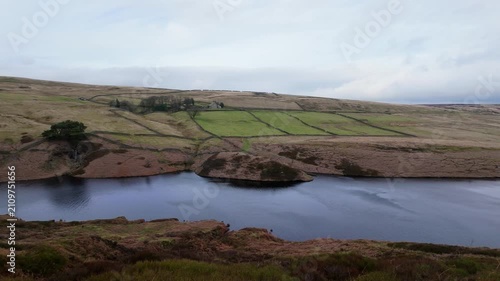 Yorkshire Moorlands in the English countryside. Bleak barren moors or pennines. Calm lake with heather covered hills.
