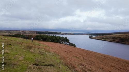 Yorkshire Moorlands in the English countryside. Bleak barren moors or pennines. Calm lake with heather covered hills.