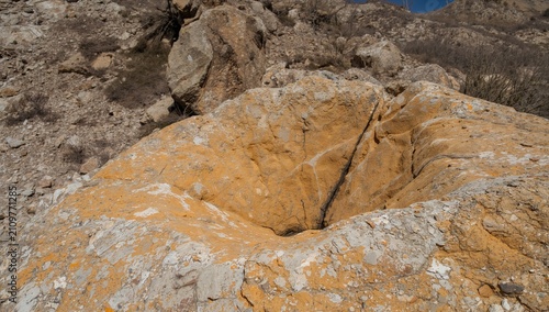 Obraz na płótnie Yellow Rock Formation with Circular Indentation Amidst a Dry Landscape