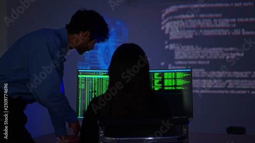 Software engineers collaborating on cybersecurity monitoring and AI powered code analysis in a modern technology workspace with multiple digital displays