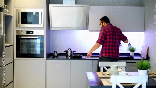 Man in Plaid Shirt Opening Oven Door While Preparing Food in Modern Kitchen

Young Man Cooking in Modern Grey Kitchen Interior With Built-in Appliances

Back View of Man Using Oven in Contemporary Kit