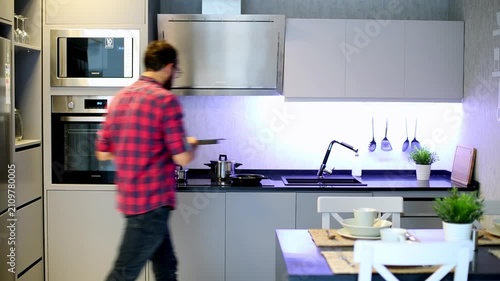 Man in Plaid Shirt Opening Oven Door While Preparing Food in Modern Kitchen

Young Man Cooking in Modern Grey Kitchen Interior With Built-in Appliances

Back View of Man Using Oven in Contemporary Kit