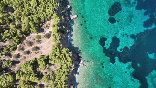 Top Down Drone Flight Over Turquoise Water and Seabed Off Agistri Rising to Reveal Coastline, Catamaran and Distant Saronic Islands