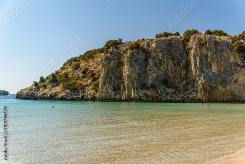 Fotografía Rugged limestone cliff headland above emerald water at Voidokilia beach, Messeni