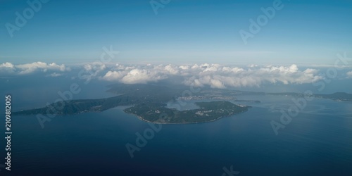 Aerial View of Serene Island Surrounded by Blue Ocean and Clouds