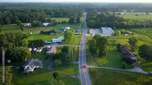Early morning in Tennessee countryside with country road and homes in rural America beside green pastures and farmland