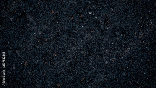 Black Gravel Texture with Small Rocks and Granules in Dark Lighting