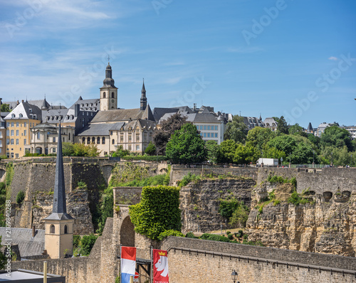 Quadro su tela Panoramic View of Old Town and Fortifications in Luxembourg City with Flag