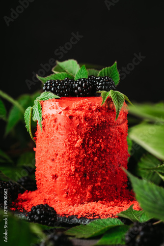 Red blackberry cake on dark wooden background. Selective focus.