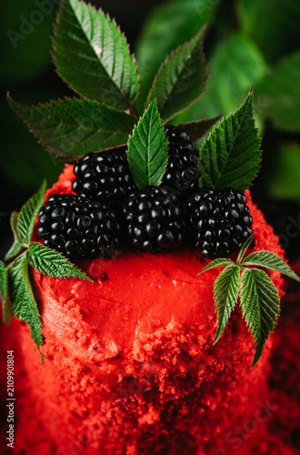 Red blackberry cake on dark wooden background. Selective focus.