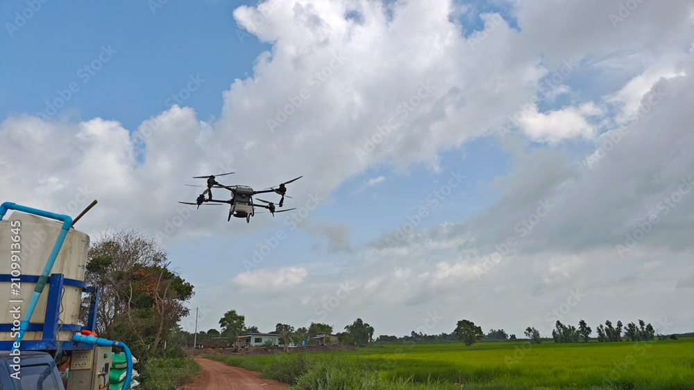 Fototapeta premium Agriculture drone fly to sprayed fertilizer on the rice fields. Industrial agriculture technology.
