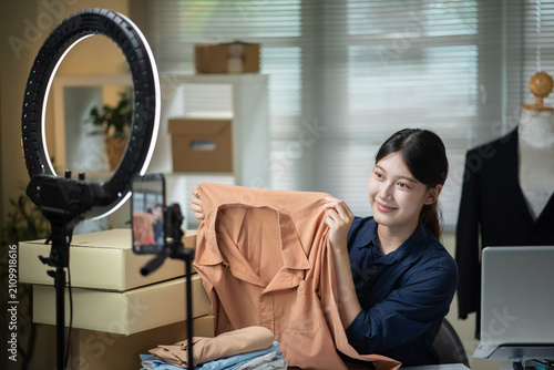 Quadro su tela Young Asian Woman Live Streaming Fashion Clothing Sales with Ring Light and Smar