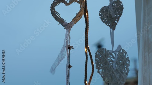 Romantic wicker heart decorations gently swaying in the wind