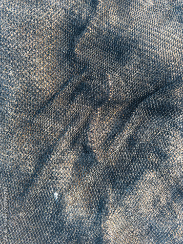 Close up texture of dark fishing net on sand beach