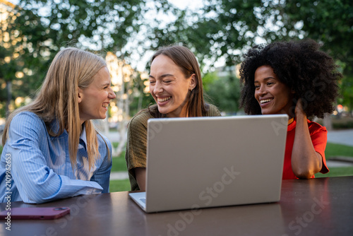 Multiracial female students collaborating on artificial intelligence project outdoors