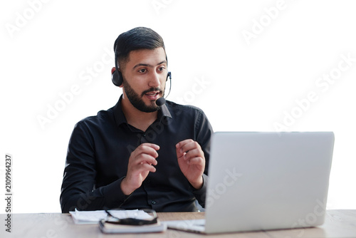 Young handsome male customer support phone operator with headset working in his office.