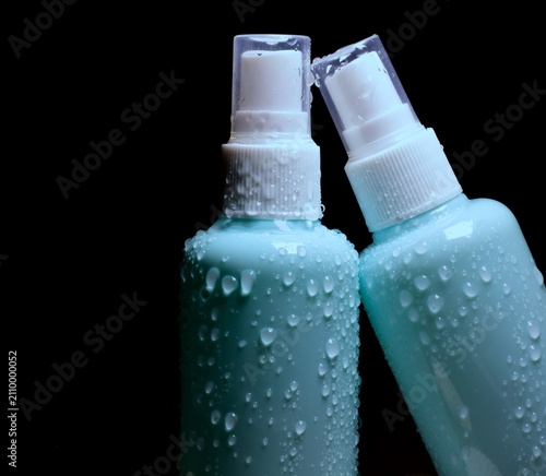 Close-up of cosmetic products on a black background.	