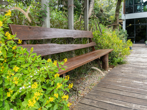 Rustic Wooden Bench in Lush Green Garden with Yellow Flowers