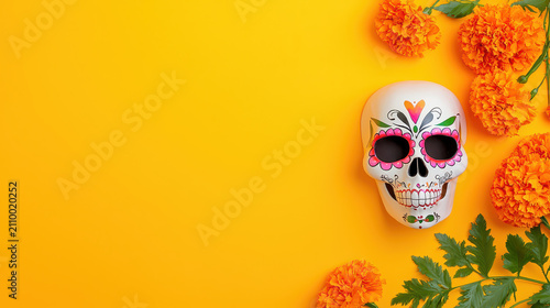Vibrant skull mask surrounded by marigold flowers on bright yellow background creates festive atmosphere