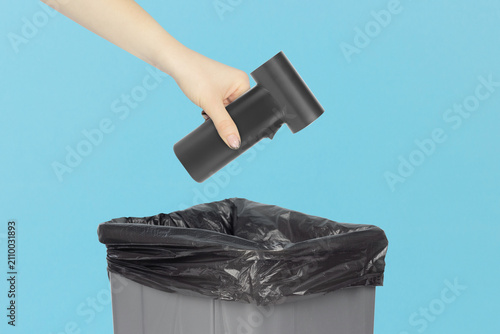 Throwing a portable electric air duster  into the trash can, holding a electric air duster in front of the trash can