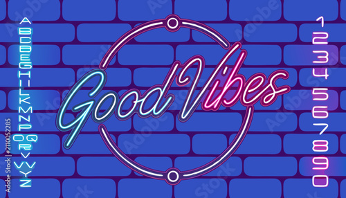 Neon sign glowing Good Vibes message on brick wall background. Vibrant retro light typography for positive energy and motivation displays.