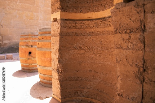 Fotografia Curved rammed earth pillar showing barrel shaped geometry next to oak wine barre