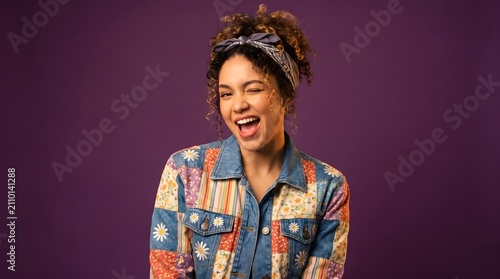 portrait of a young woman winking with a fun, expressive Smile, wearing a colorful retro-style jacket against a solid purple background, conveying an energetic, vibrant, and joyful mood