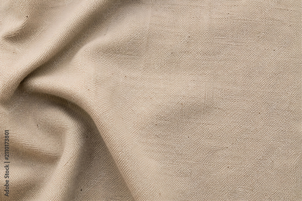 Fototapeta premium Natural beige linen fabric texture background with soft folds and blank copy space for product mockup