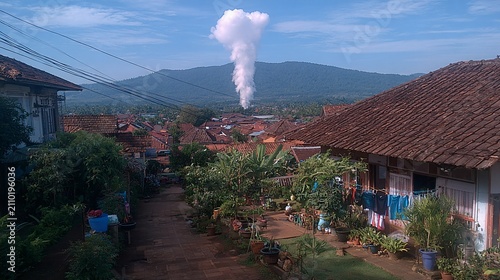 Serene Indonesian Village Landscape with Distant Volcano, Lush Greenery and Local Life is visible