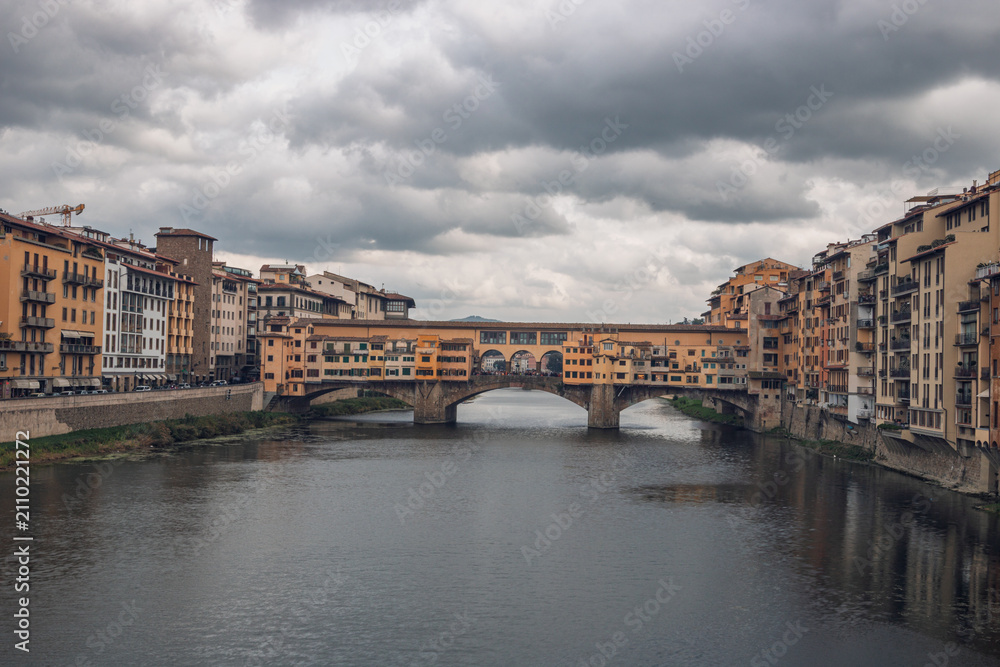 Fototapeta premium Famous historic Ponte Vecchio bridge and old buildings along the Arno river in Florence Italy