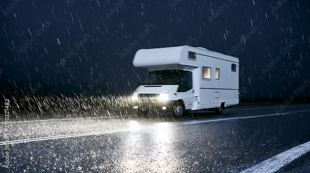 Obraz premium White Recreational Vehicle Travel Highway Stormy Night Harsh Weather Conditions Dark Sky Headlights Shine on Wet Road Adventure Journey Concept