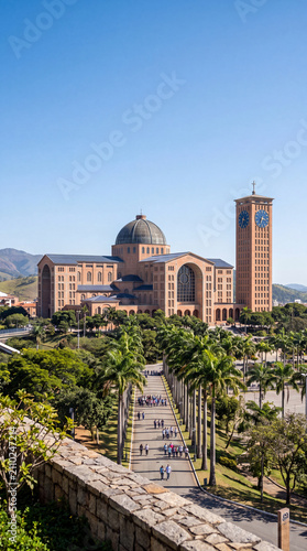 The majestic Basilica of the Shrine of Our Lady of Aparecida in Brazil, surrounded by palm trees with pilgrims walking along the path on a sunny day.