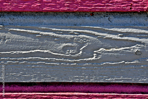 Old painted wood plank with raised grain casting shadows framed by upper and lower pink boarder