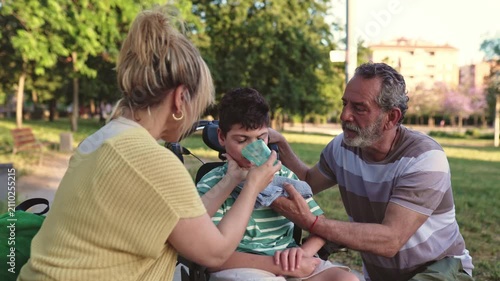 Mother and grandfather caring for son in a wheelchair