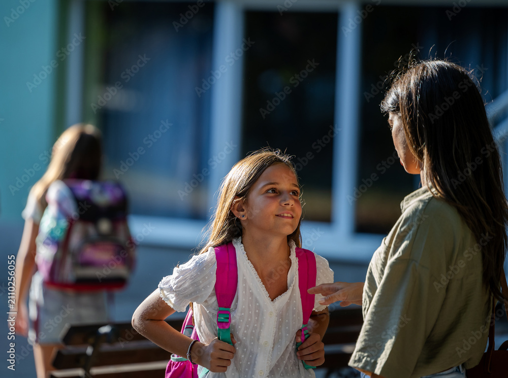 Fototapeta premium Mom and daughter share a joyful moment after school