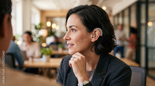 Professional woman with hearing aid in modern office setting