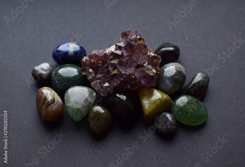 Foto Amethyst quartz druse and round agate and fluorite stones on a gray background