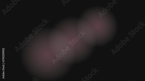 Abstract moving bokeh light shapes softly glow on a dark background